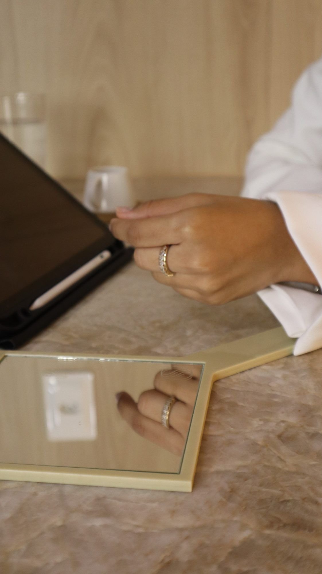 Mãos da Dra. Débora com um tablet e caneta, planejando o protocolo do paciente.