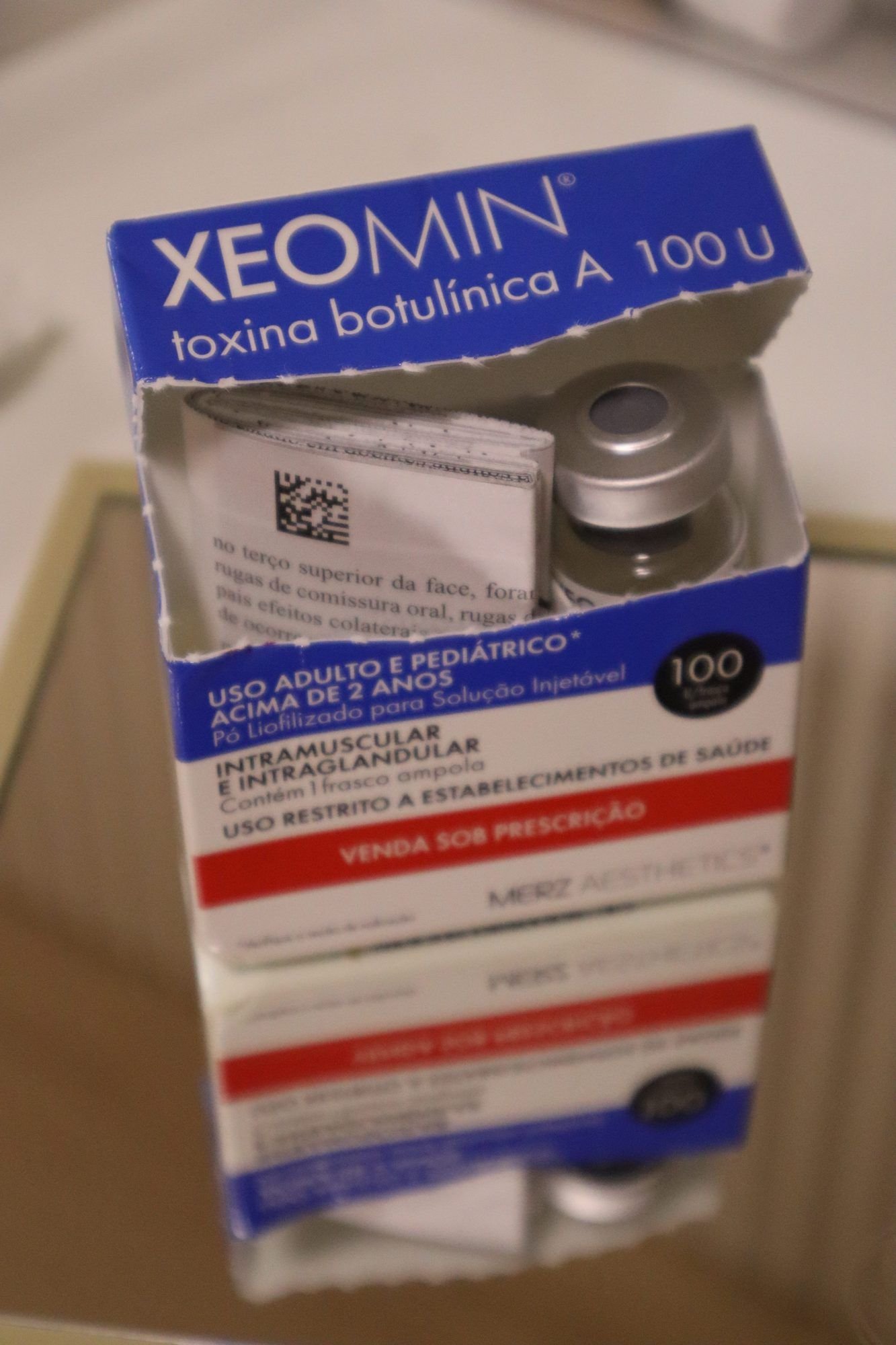 Caixa de toxina botulínica aberta, com o frasco-ampola à vista.